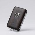 Wooden key fob with Volvo logo on a light gray background