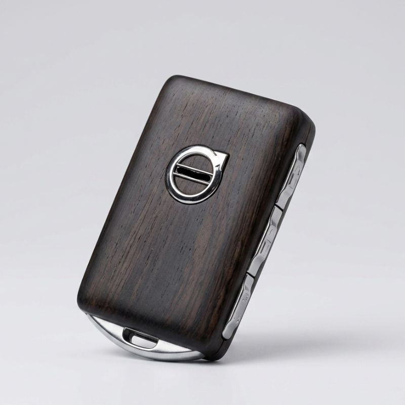 Wooden key fob with Volvo logo on a light gray background