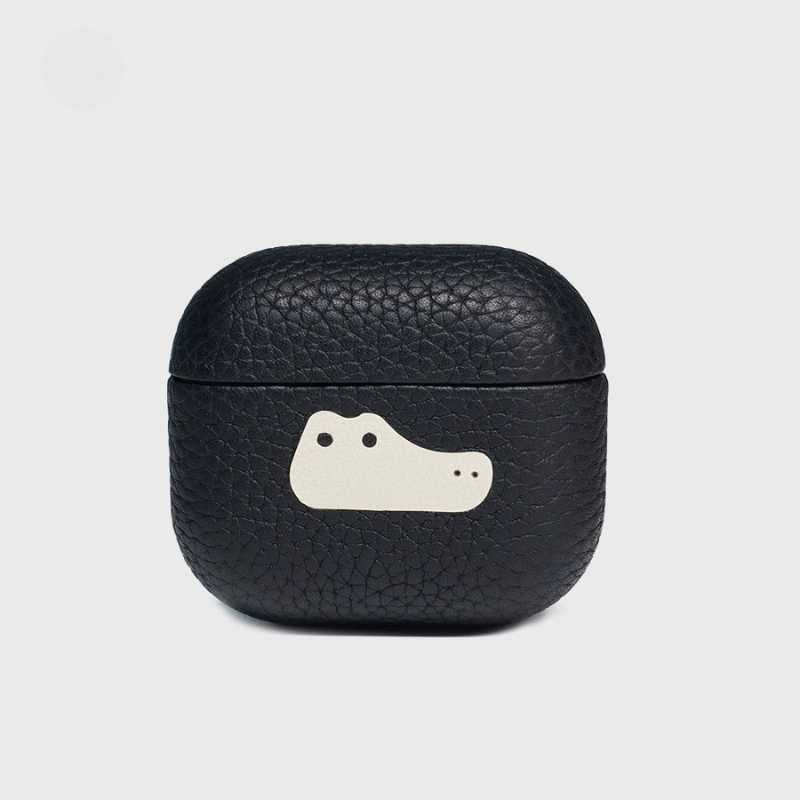 Handmade leather AirPods Pro 3 case made of lychee-grain cowhide Black leather airpod case with a cartoon face design on a light gray background