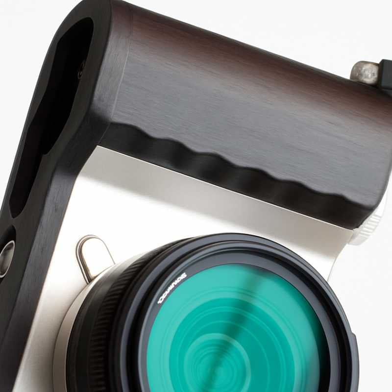 Macro shot of the polished dark ebony grain and texture on the Leica camera handgrip.