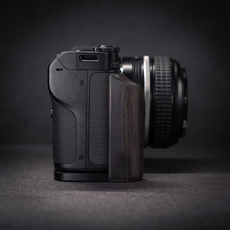 Camera with wooden grip on a dark background