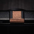 Ricoh GR4 Hotshoe Cover Wood iWoodStore Close-up of a wooden belt buckle on a black belt with a dark background