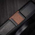Ricoh GR4 Hotshoe Cover Wood iWoodStore Close-up of a device with a wooden switch and black casing.