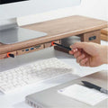 Wood Telescopic Retractable Data Cable Charging Cable For Desk iWoodStore Hand plugging a pen into a USB hub attached to a desk with a computer setup.