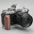 Nikon zf camera with wooden grip silver base on a wooden surface